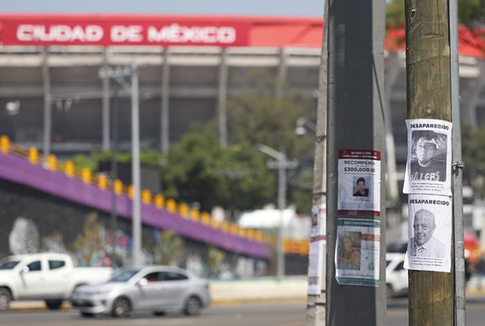 Familias de desaparecidos pegan fichas de búsqueda en el Estadio Azteca, inaugural del Mundial
